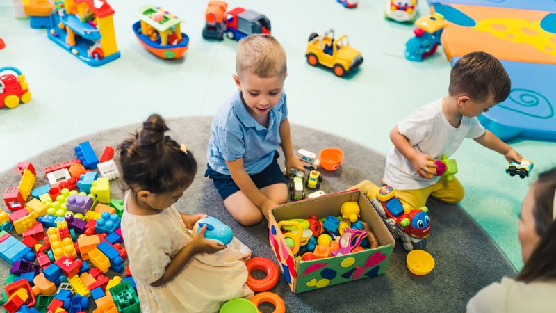 Two toddlers playing with colourful building blocks.