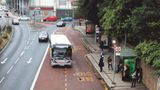 A Fastrack bus pulling into a bus stop off of a bus lane