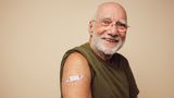 Senior man has plaster on arm after being vaccinated