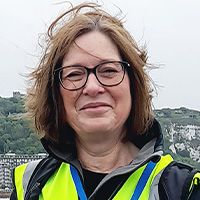 Andrea Olver leaning against seafront railings