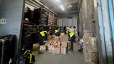 Three Kent Trading Standards officers search through boxes of illegal vapes in a warehouse