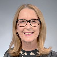 Sarah Hammond is smiling at the camera during a headshot photoshoot