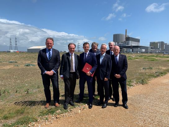 Group stands on wasteland at Dungeness with the Power Station in the background