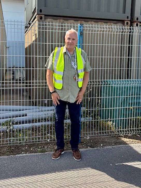 Alan Heyes, Chief Executive of Therapy Partners, wearing a hi-vis jacket in front of a construction site