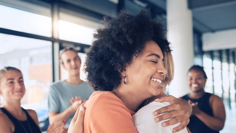 Women colleagues support each other with a hug