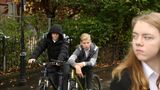 Girl looking anxious surrounded by boys on bikes