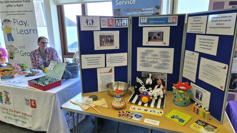 A display board with information about Portage is on one of the tables at the SEND Roadshows accompanied by toys