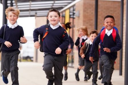 Children in school uniform running out of class