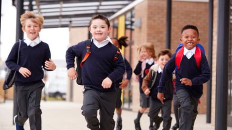 Children in school uniform running out of class