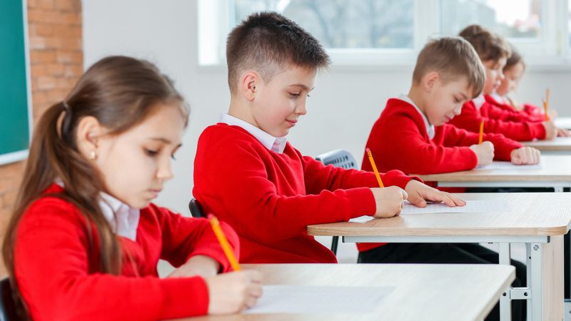 Children in uniforms taking an exam