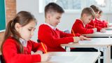 Children in uniforms taking an exam