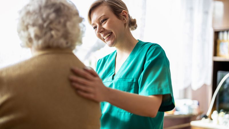 Nurse supports elderly woman