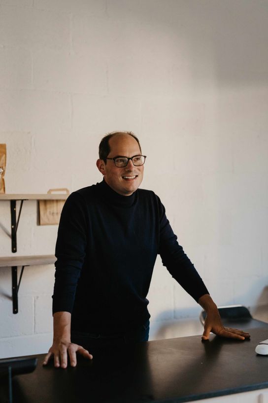 Profile picture of Gilda bakery founder Jon Warren leaning on a counter