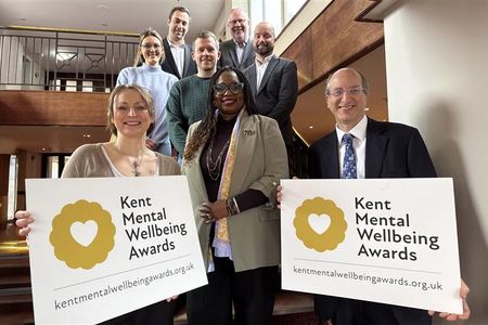 Award judges standing in staircase holding award banners