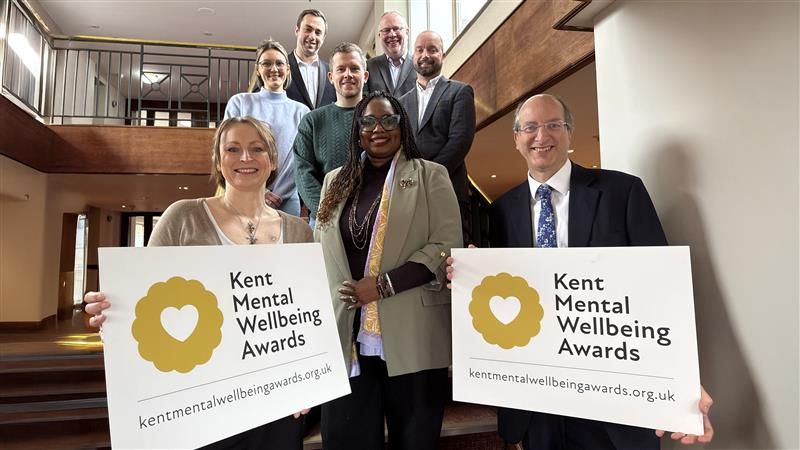 Award judges standing in staircase holding award banners