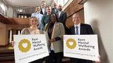 Award judges standing in staircase holding award banners