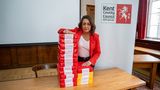 Leader of the Council, Linden Kemkaran, is standing in front of two piles of printer paper - one pile is 4 reams of paper high, the other pile is 12 reams of paper high. Her concerned face is staring directly into the camera, while her hand rests on one of the piles. Each ream of paper is labelled &lsquo;1000&rsquo;, representing 1000 unaccompanied asylum seeking children who have entered our care since 2006. The contrasting piles illustrate that between 2006-2015 approximately 4000 children came into care and between 2016-2025 approximately 12000 children came into care - a threefold increase in the last decade. Most of these 12000 children are now young adults, but they remain Care Leavers who KCC is responsible for until they turn 25.