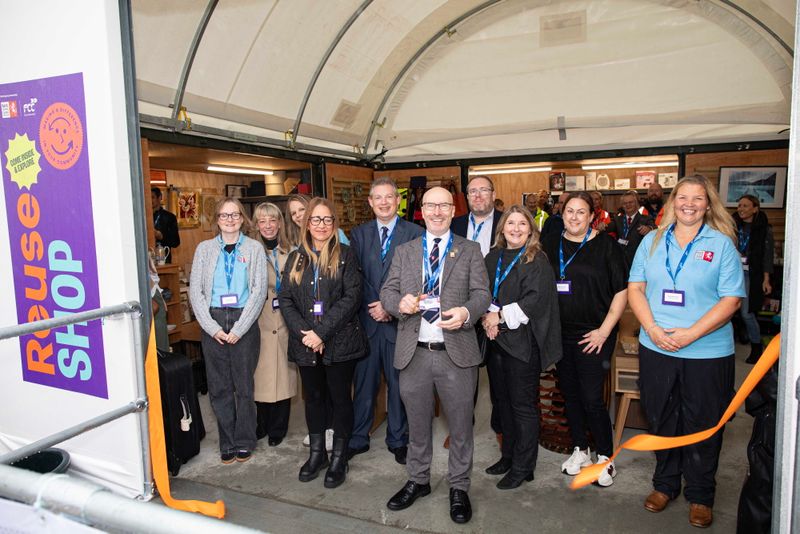Group of staff and partners at the entrance to the Reuse Shop at New Romney Household Waste Recycling Centre during the official ribbon-cutting opening ceremony.