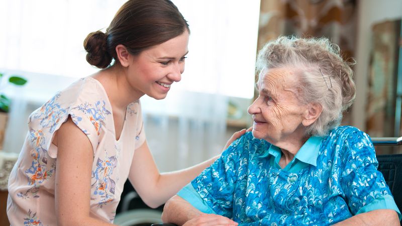 A careworker holding the arm of an elderly lady