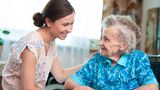 A careworker holding the arm of an elderly lady