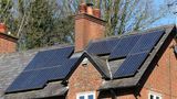 Solar panels on a house with a chimney in the middle