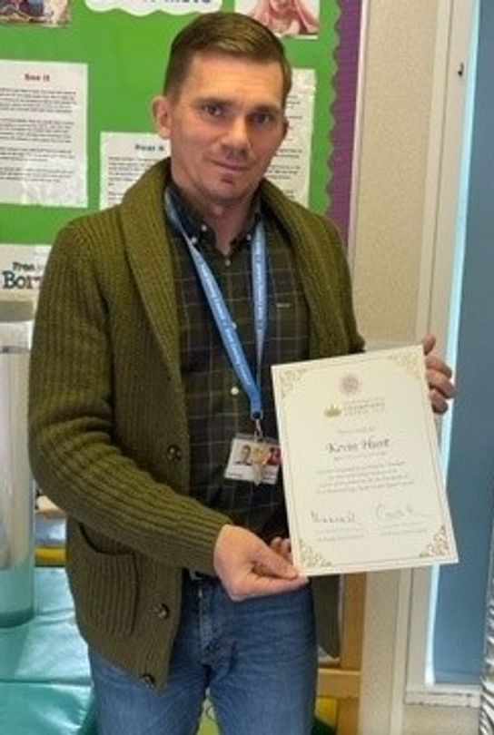 Kevin Hunt holding his Coronation Champion certificate
