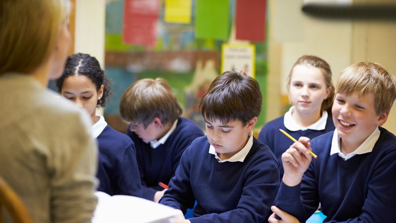 Pupils in school uniform being taught by a teacher