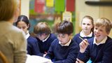 Pupils in school uniform being taught by a teacher