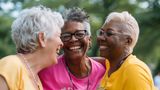 Three mature women in sports clothing laughing