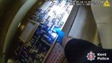 A gloved hand inspecting illegal tobacco products in a cabinet by torchlight