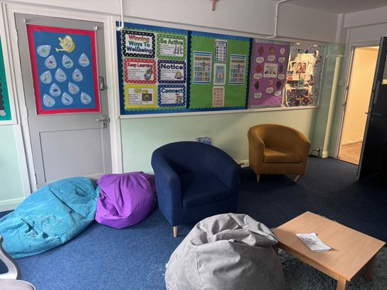 A room with bean bags and signs related to supporting mental health on the wall