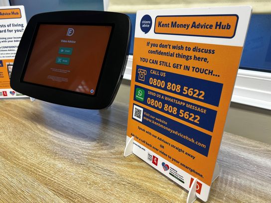 The orange and blue video kiosk on a table top next to an information leaflet at the centre in Aylesham