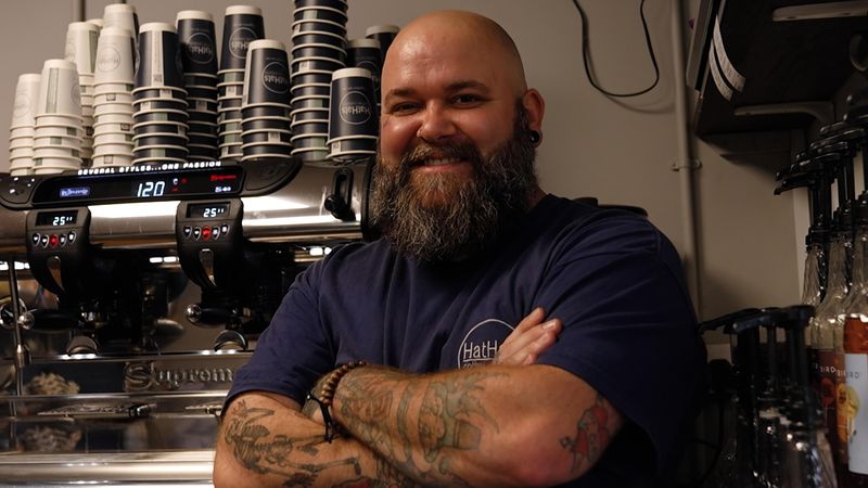 HatHat coffee shop manager in front of coffee machine