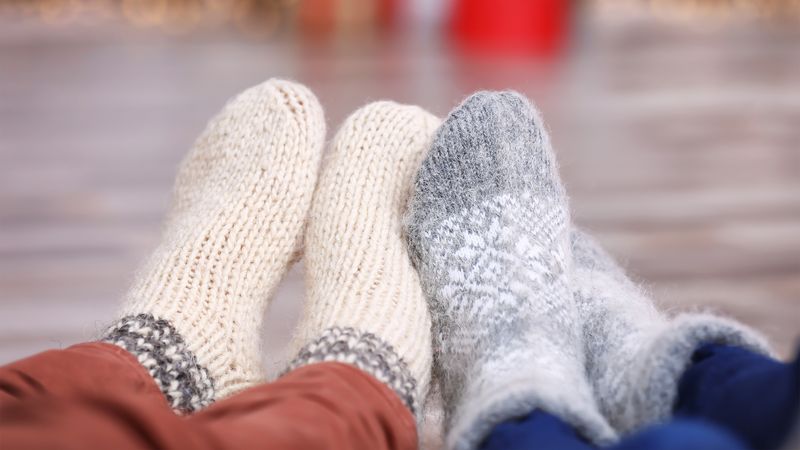 Two pairs of feet in socks next to one another