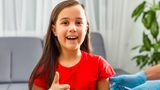 Young girl gives thumbs up as she has a vaccination